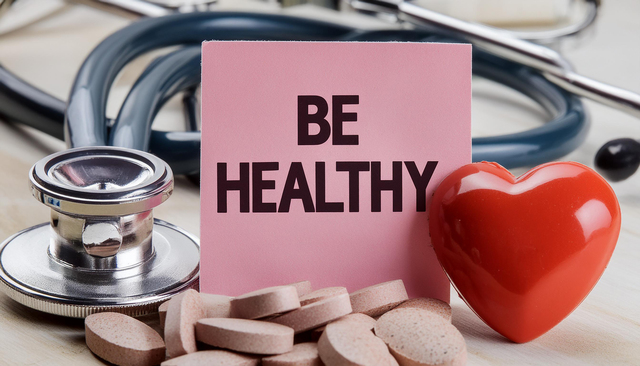 Be healthy- advice on pink sticky note near stethoscope and tablets.concept of health life