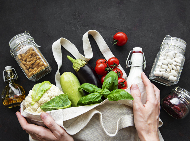 Zero waste concept. Eco bag with fruits and vegetables, glass jars with beans,  pasta. Eco-friendly shopping and cooking concept, flat lay