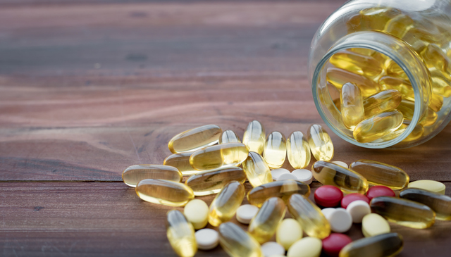 Medicine concept on wood background. Concept of medicine in medical. Pills, dietary supplements that are stacked together.